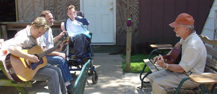 dougandgrandpa.jpg - Over the years I have often wished that I could play some sort of music so I could make some music with my Son Doug. I bought a guitar in 2004 and learned a few chords and here I am playing with Doug.It was a good day in the summer of 2005.